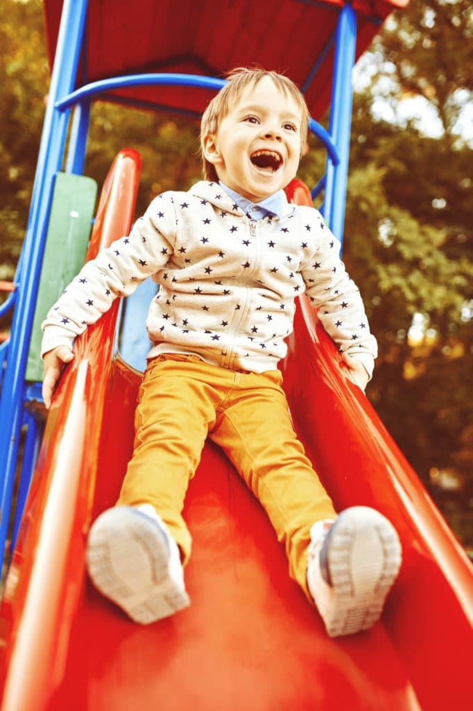 Little boy playing on children's slides